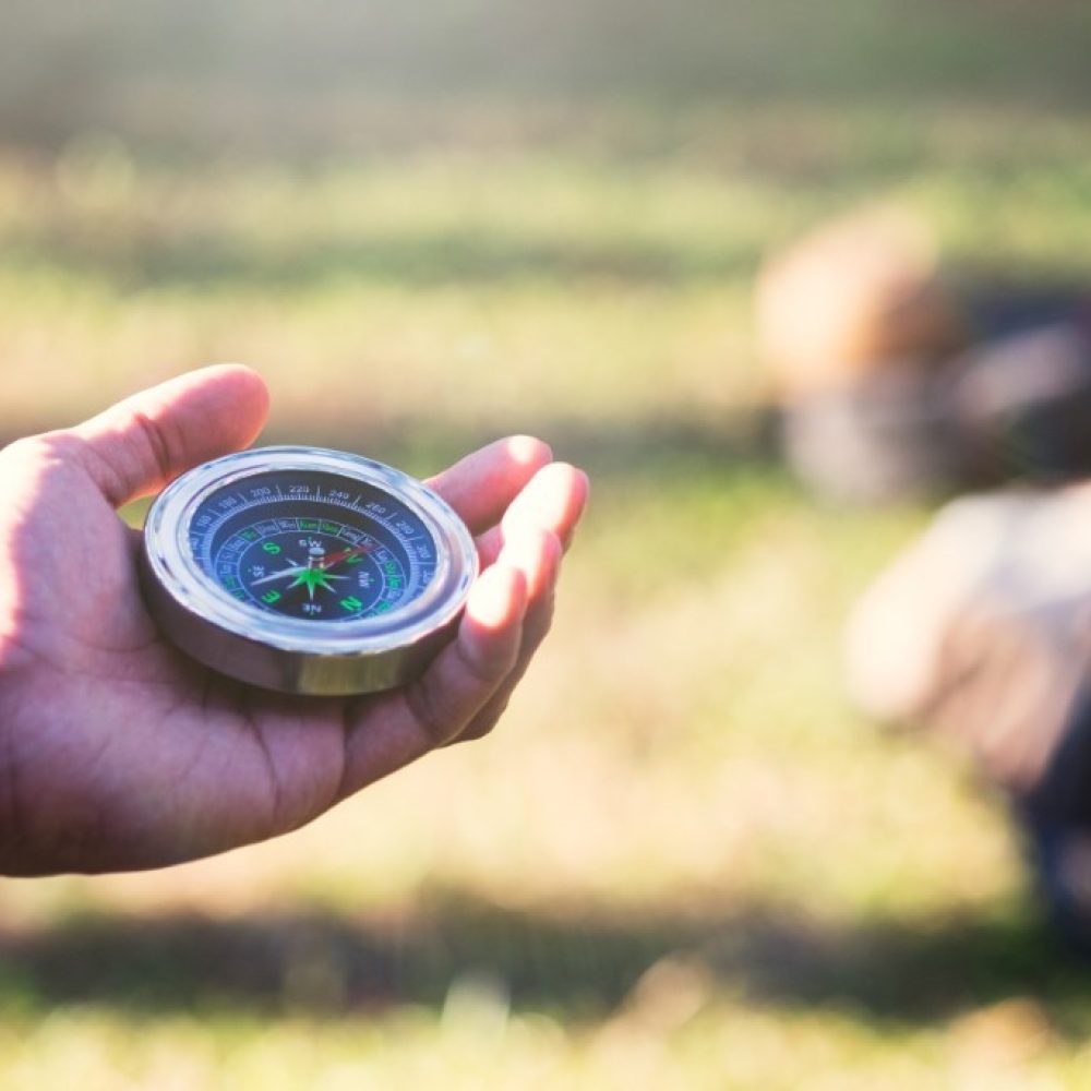 hiker-searching-direction-with-compass-forest